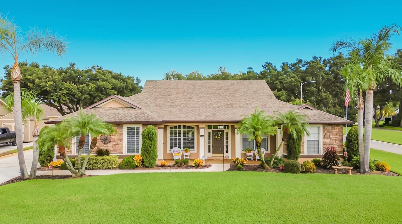Front of 5243 Hammock Pointe Ct, St. Cloud, FL — stone accents, covered entry and landscaped beds with palms