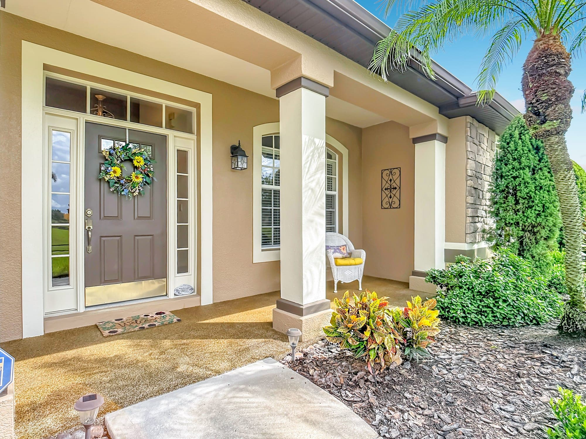 Covered front entry at 5243 Hammock Pointe Ct with columns, arched window and landscaping