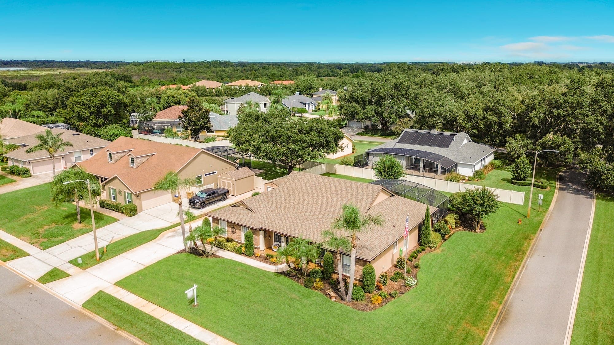 Aerial view of 5243 Hammock Pointe Ct on its corner lot, showing the screened pool enclosure and shed